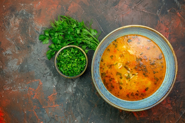 top view rice soup blue bowl chopped greens bowl parsley bunch dark red table - Суп картофельный на грибном отваре