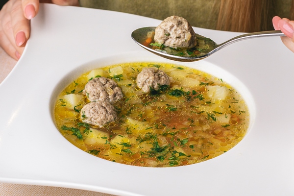 woman eats her lunch restaurant white soup 1 - Суп с фрикадельками