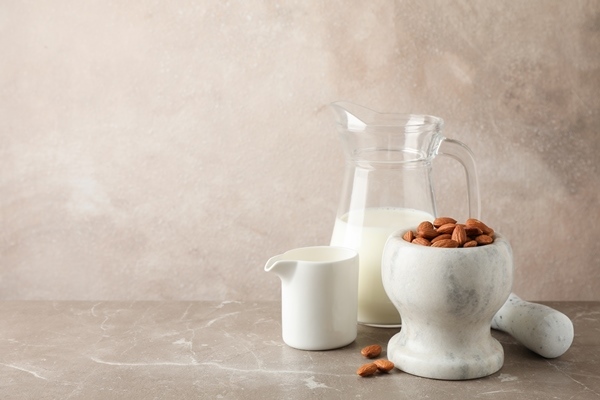 jug almond milk mortar with almond seeds brown table - Молоко миндальное (старинный рецепт)