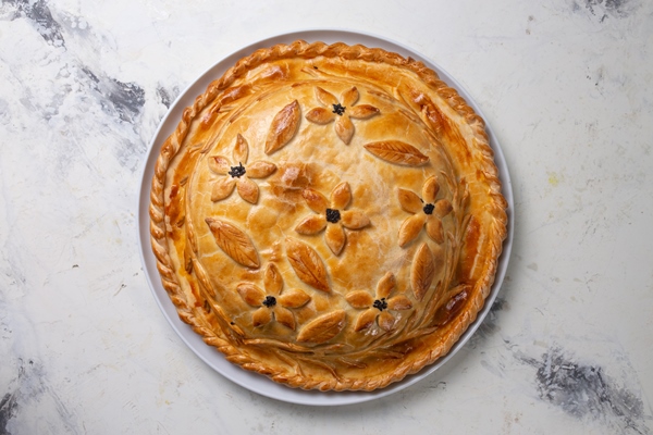 rustic homemade round meat pie with golden crust highlighted white background top view - Свадебный каравай постный