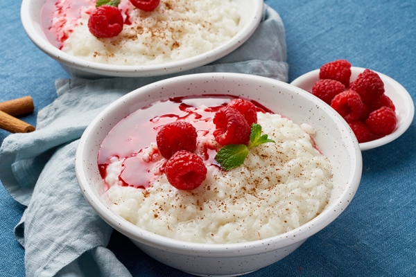 rice pudding french milk rice dessert with raspberries blueberries dark background side view - Рисовая каша диетическая