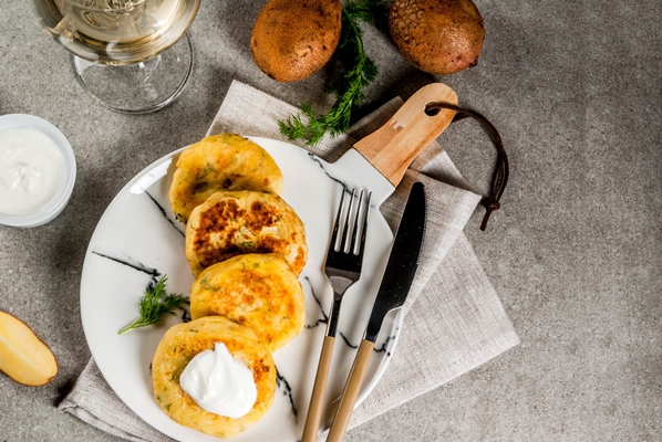 vegan food cheese mashed potato pancakes cutlets with dill and sour cream on gray stone top view - Котлеты из кабачков