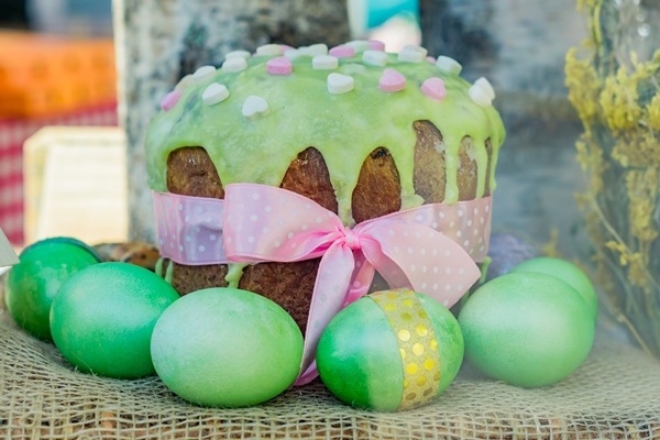 close up easter cake with glaze green colored eggs - Фисташковый кулич с кремом