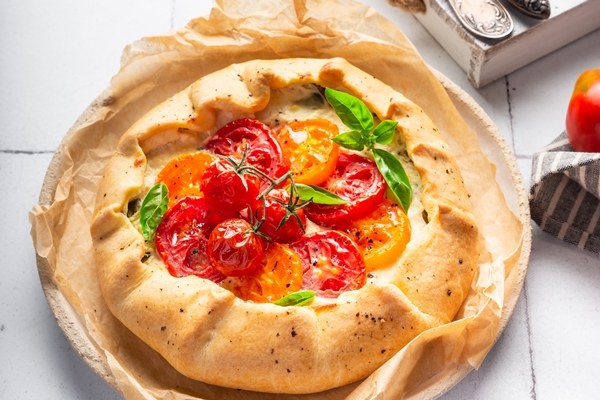 fresh homemade galette with tomatoes ricotta cheese basil white tile background - Творожная галета с сыром фета и помидорами