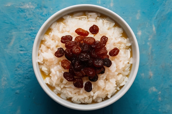 raisins bowl rice pudding blue background high quality photo - Кутья поминальная рисовая с изюмом