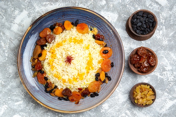 top view yummy shakh plov cooked rice dish with raisins inside plate white floor - Плов с сухофруктами и орехами