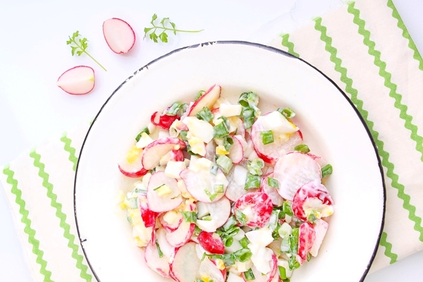 salat s red koi zelenym lukom i aicom v beloi tarelke belyi fon - Салат с кальмарами и редисом