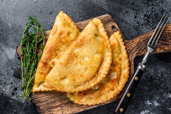 zarenye v masle cebureki s masom i zelen u tradicionnye bluda kavkazskoi kuhni cernyi fon vid sverhu - Чебуреки