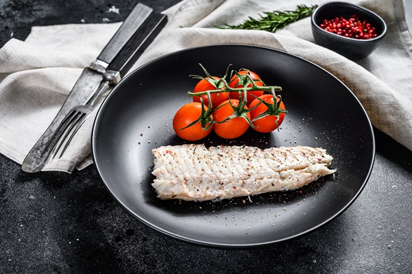 tusenoe file treski s pomidorami cerri cernyi fon vid sverhu - Секреты приготовления вкусной отварной рыбы
