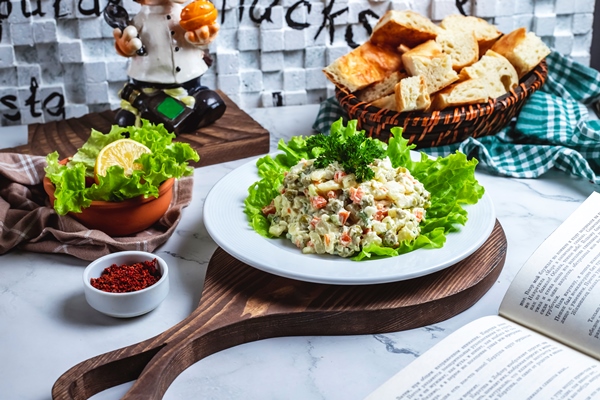 vid sboku stolicnyi salat na list ah salata s hlebom i lomtikom limona na stole - Салат рассольный